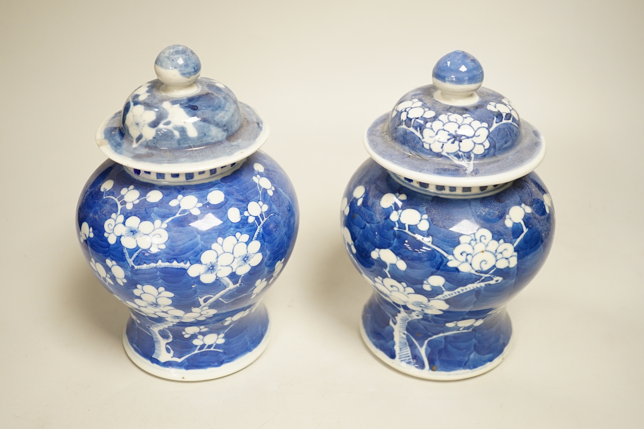 A pair of Chinese blue and white prunus pattern vases and covers, 21cm high